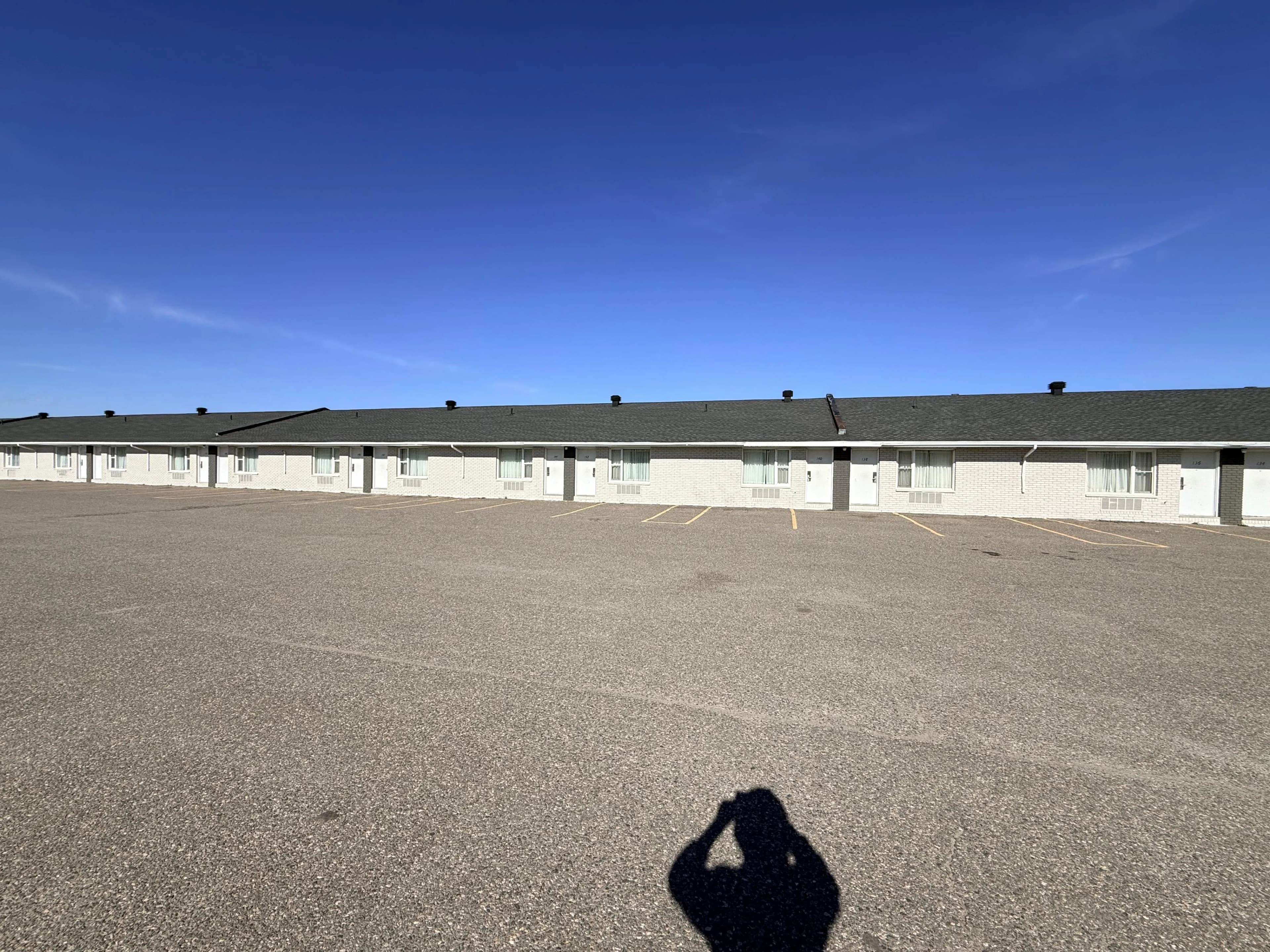 Quality Inn, New Liskeard — Finished elevation looking back along the rooms, roof edge cut in charcoal