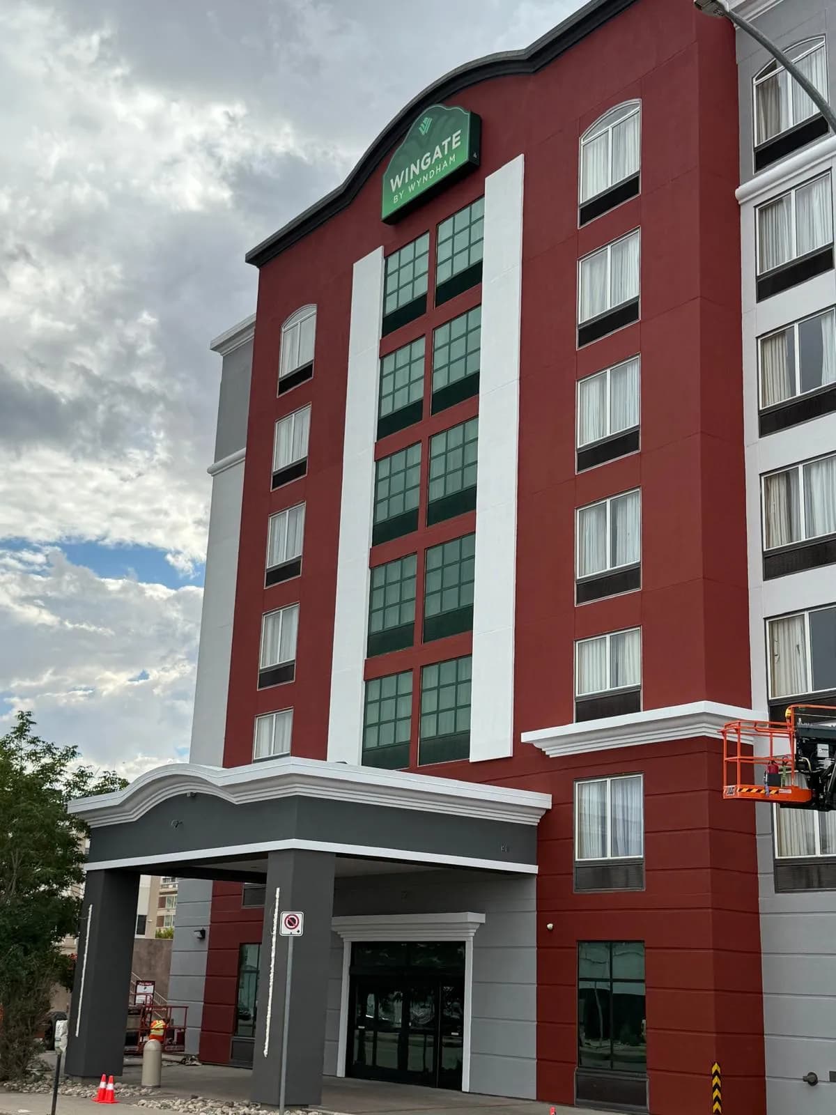 Wingate by Wyndham, Regina — Entrance corner at dusk, cornice and canopy finished